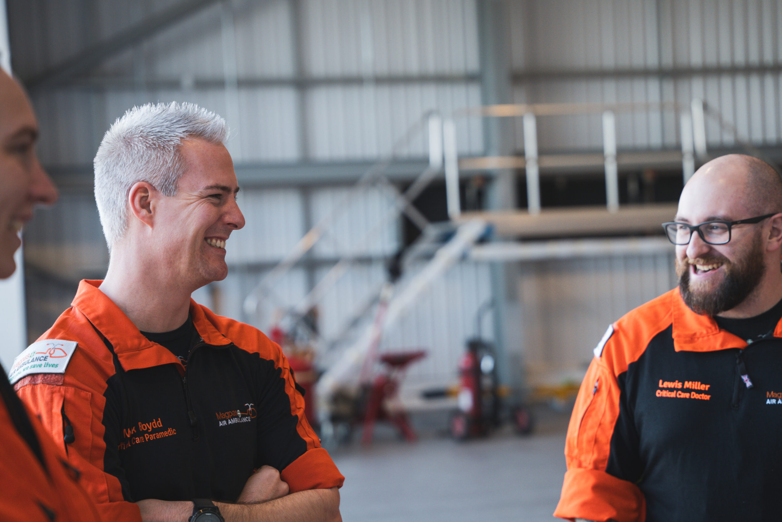 Paramedics and critical care doctors laughing in the air ambulance hangar